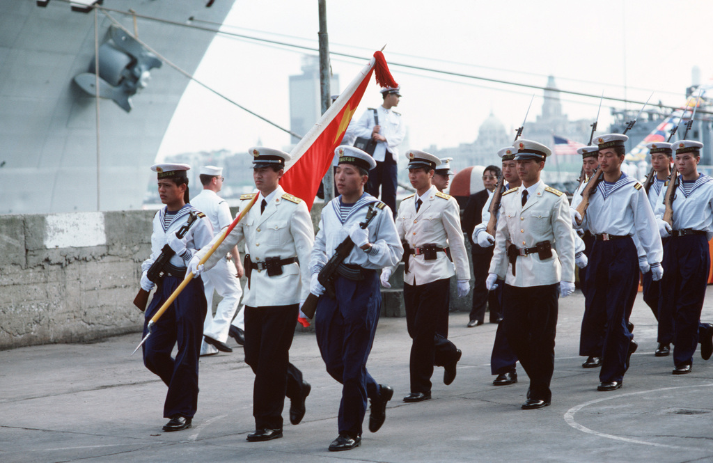 A Chinese Navy Color Guard Leads A Formation Of Sailors As They March