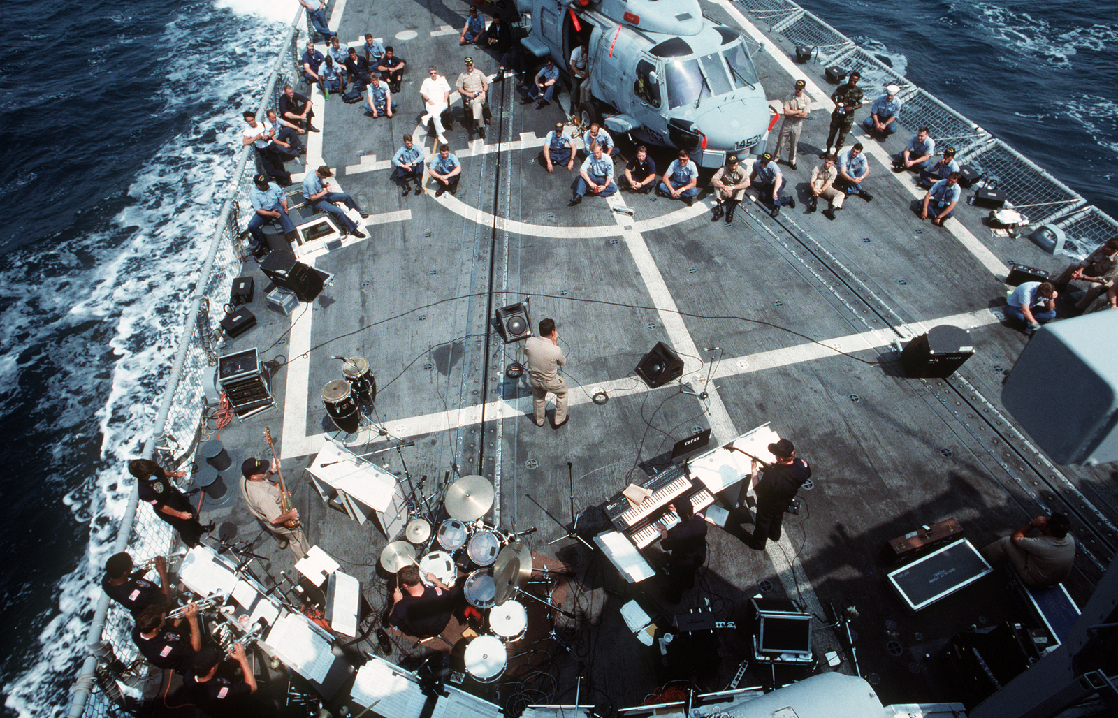 Sailors Sitting Around An SH 60B Sea Hawk Helicopter On The Guided