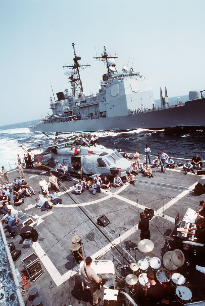 Sailors Sitting Around An SH 60B Sea Hawk Helicopter On The Guided