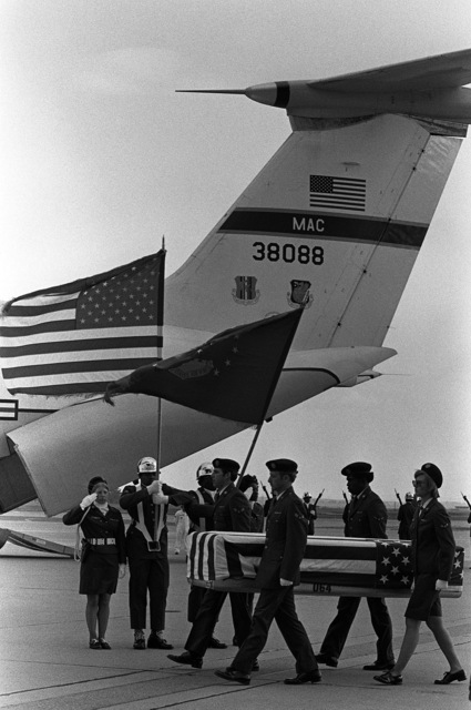 An Air Force Honor Guard Stands At Attention While Pallbearers Carry