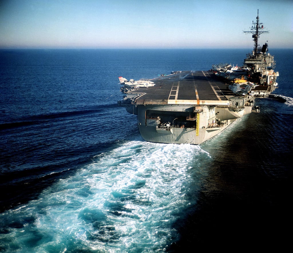 An elevated starboard quarter view of the aircraft carrier USS KITTY ...