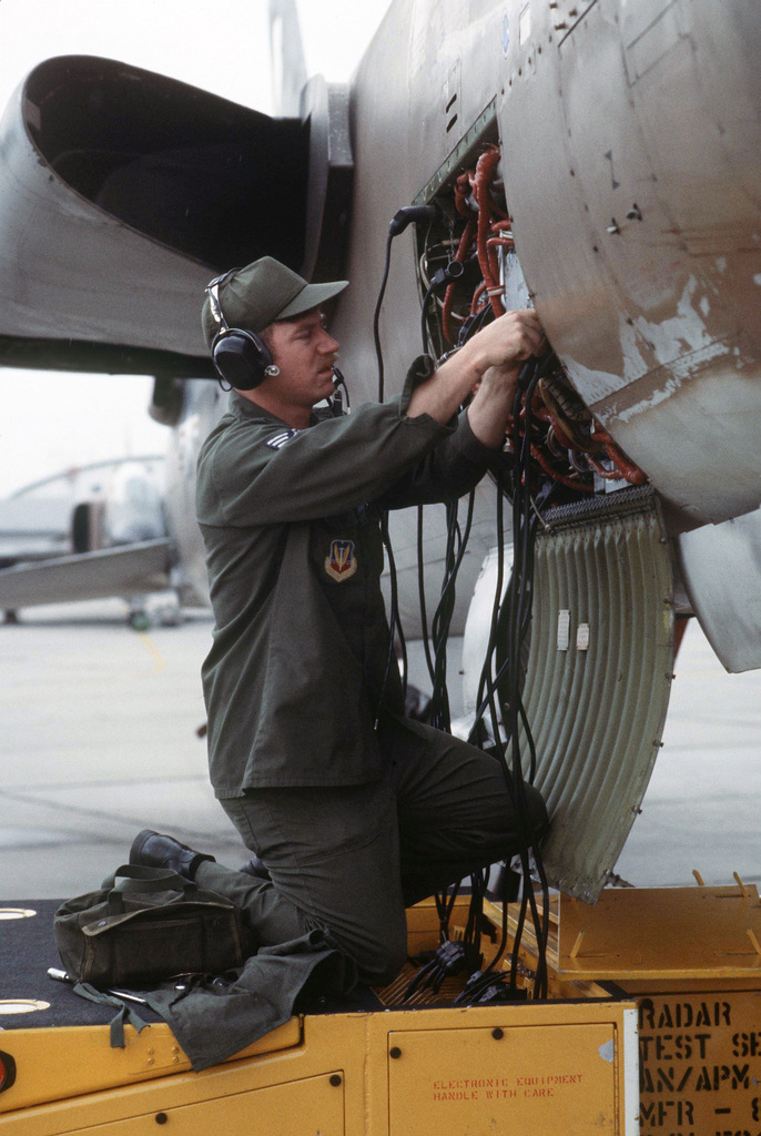 An AIRMAN checks a radar unit on an F 105 Thunderchief aircraft