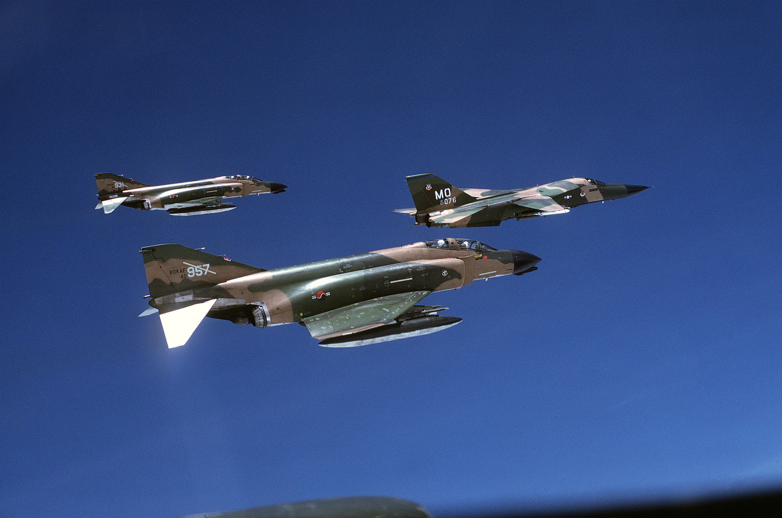 An air-to-air right side view of a US Air Force F-111 aircraft followed ...