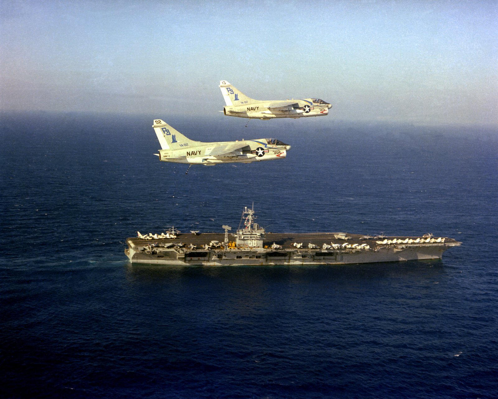 An Aerial Starboard View Of The Nuclear-Powered Aircraft Carrier Uss Nimitz  (Cvn-68) Underway With Two A-7E Corsair Ii Aircraft From Light Attack  Squadron 82 (Va-82) In Flight Above The Ship - Nara