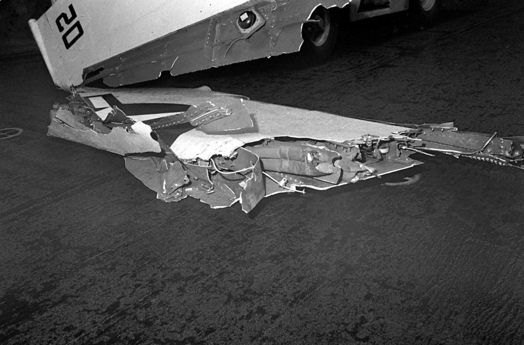 The severed wing tip of an F-4 Phantom II aircraft rests on the flight ...