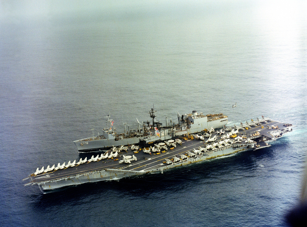 An aerial port view of the aircraft carrier USS MIDWAY (CV 41) and the ...