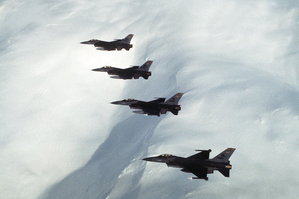 AN air-to-air left side view of four F-16 Fighting Falcon aircraft from ...