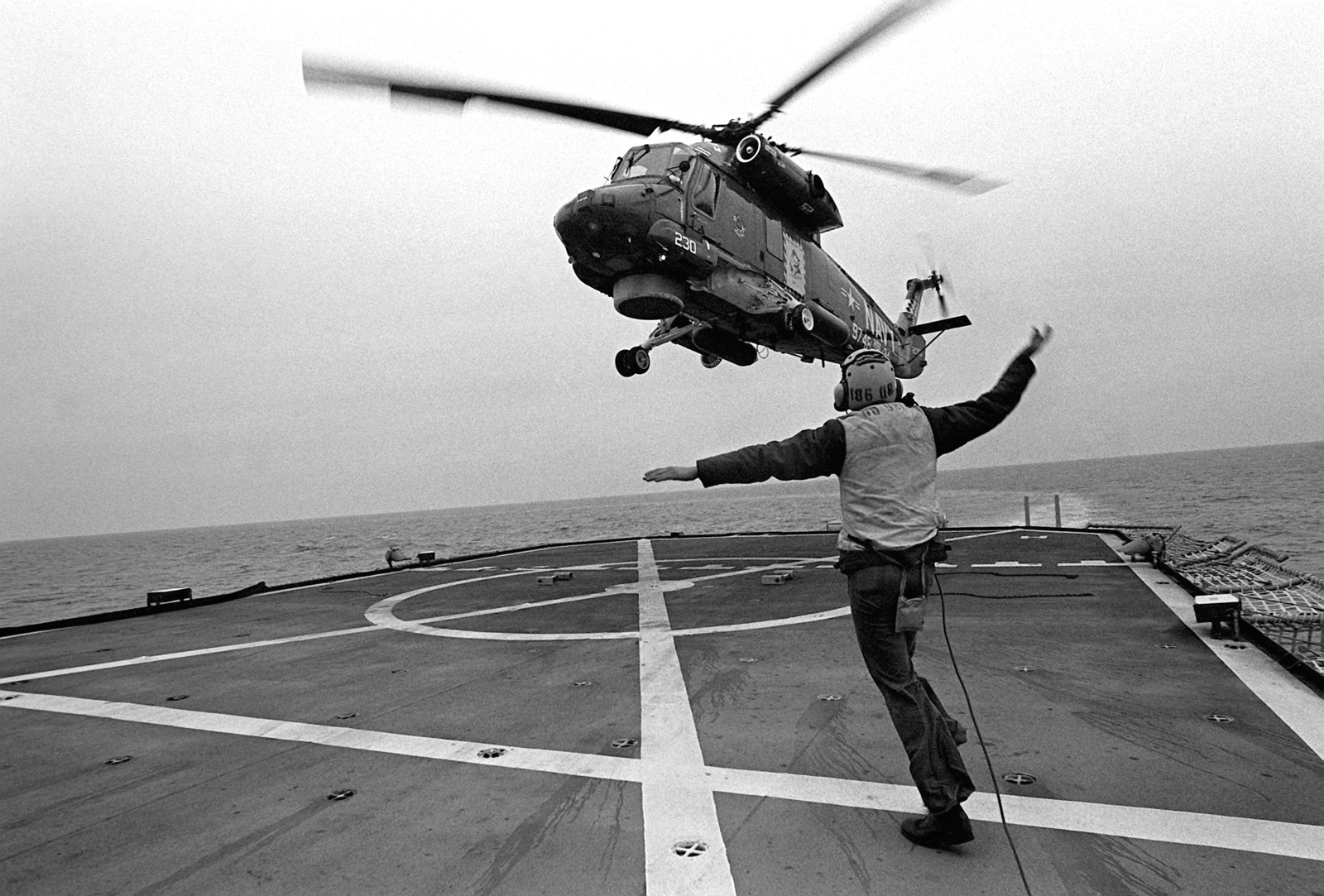 A flight deck crewman signals to an SH-2 Seasprite light airborne multi ...