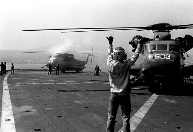 A flight deck crewman directs the pilot of a Helicopter Mine ...