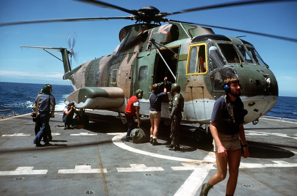 An Air Force HH-3 helicopter lands aboard the ammunition ship USS MOUNT ...