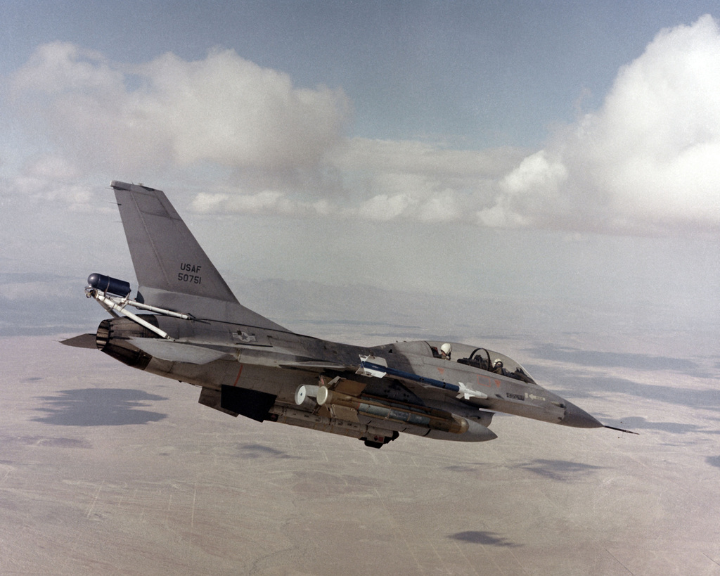 An air-to-air right side view of an F-16B Fighting Falcon aircraft with ...