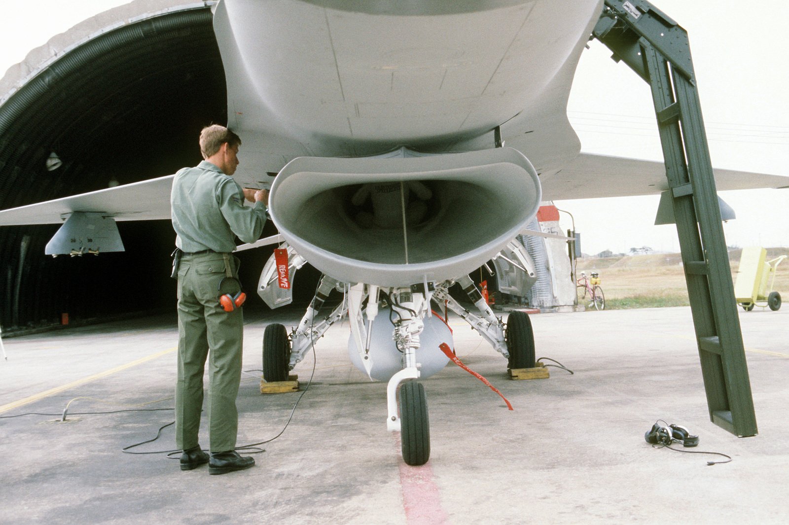 A Ground Crewman Performs Maintenance On An F 16 Fighting Falcon Aircraft As A Specialist Works On The Interior Of The Intake The Aircraft Is Assigned To The 8th Tactical Fighter Wing