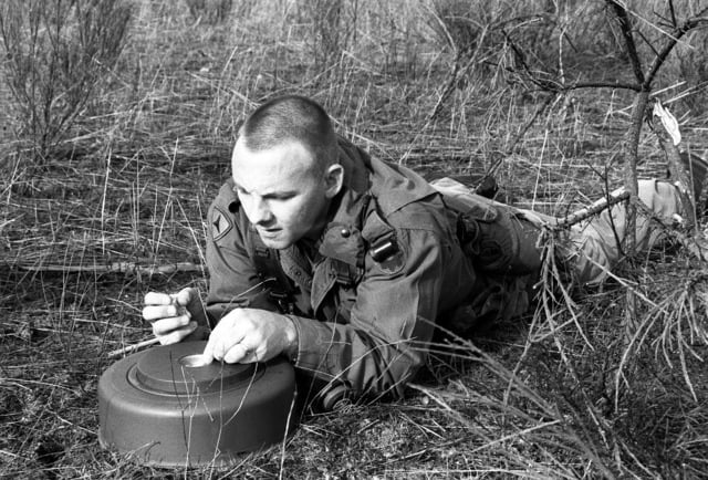 SSGT Larry Kemp of Co. A, 15th Eng. Bn., packs C4 into the well of an M ...