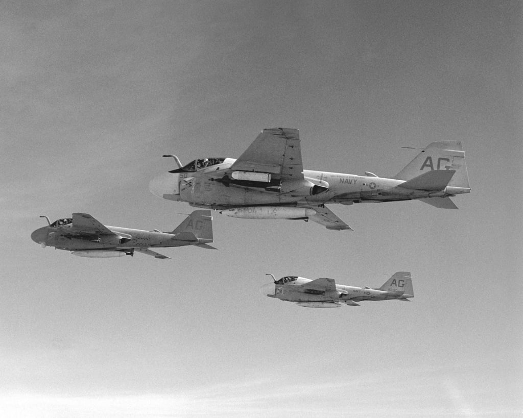 An air-to-air left side view of three A-6E Intruder aircraft with a new ...