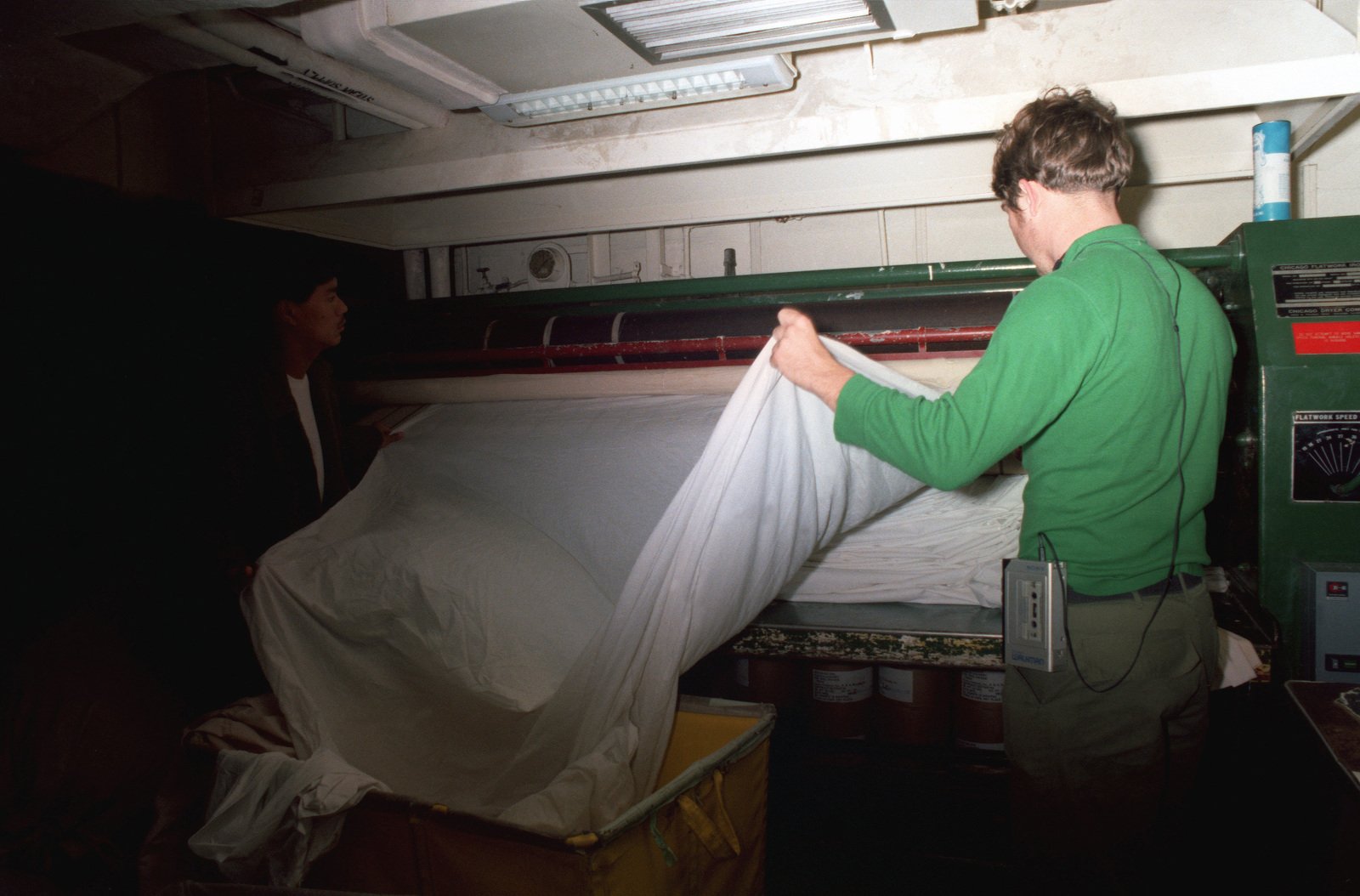 Crewmen work in the laundry area aboard the nuclear-powered aircraft ...