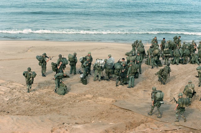 US Marines gather on the shoreline to await the arrival of a utility ...