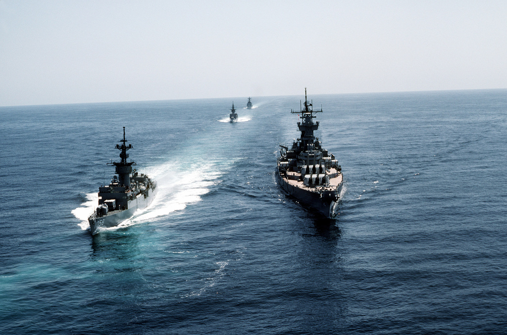 Aerial bow view of the battleship USS NEW JERSEY (BB-62) (right) and ...