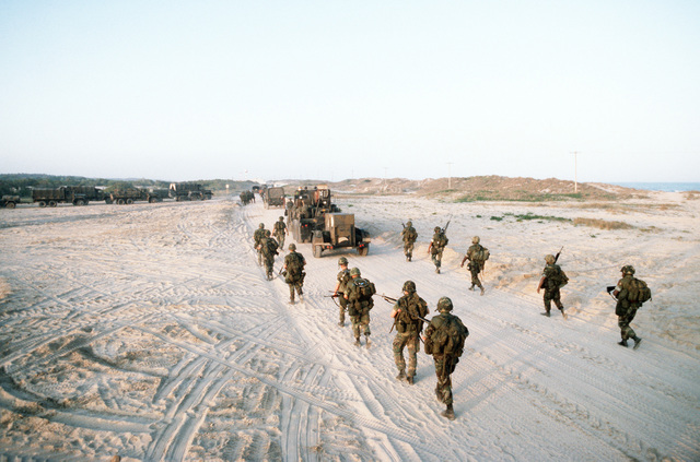 Marines move their equipment across the causeway during Exercise SOLID ...