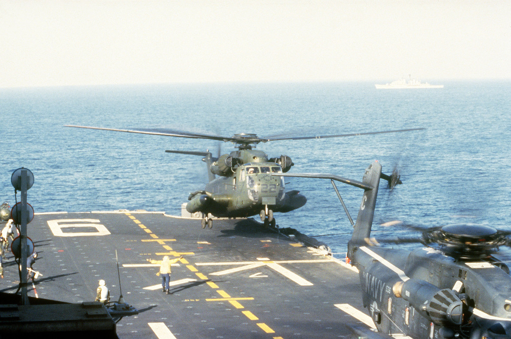 A CH-53 Sea Stallion helicopter lands on the aft flight deck of the ...