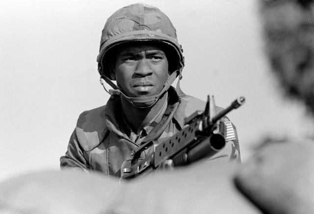 A Marine armed with an M-203 grenade launcher stands guard in a bunker ...