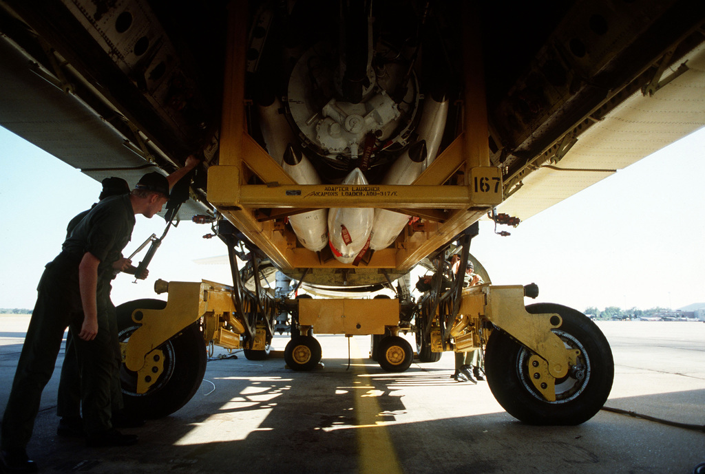 Munitions Personnel Use A Weapons Loader To Load Missiles Into The Bomb ...