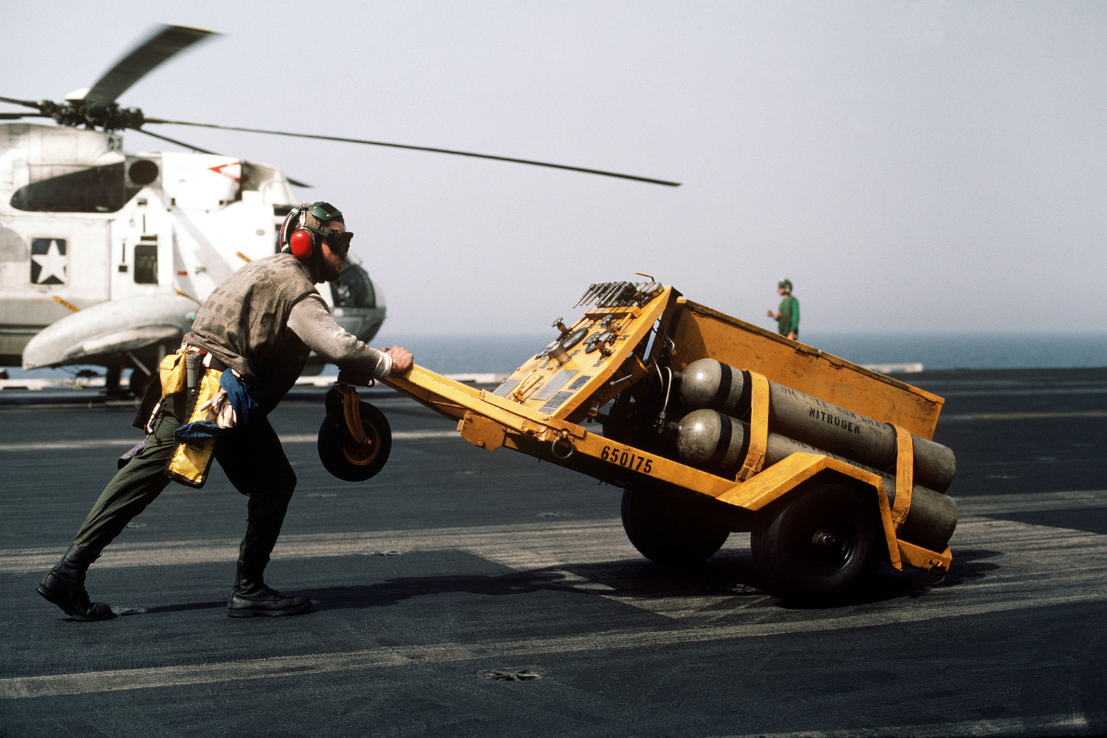 A Flight Deck Crewman Aboard The Nuclear Powered Aircraft Carrier Uss Enterprise Cvn Pushes