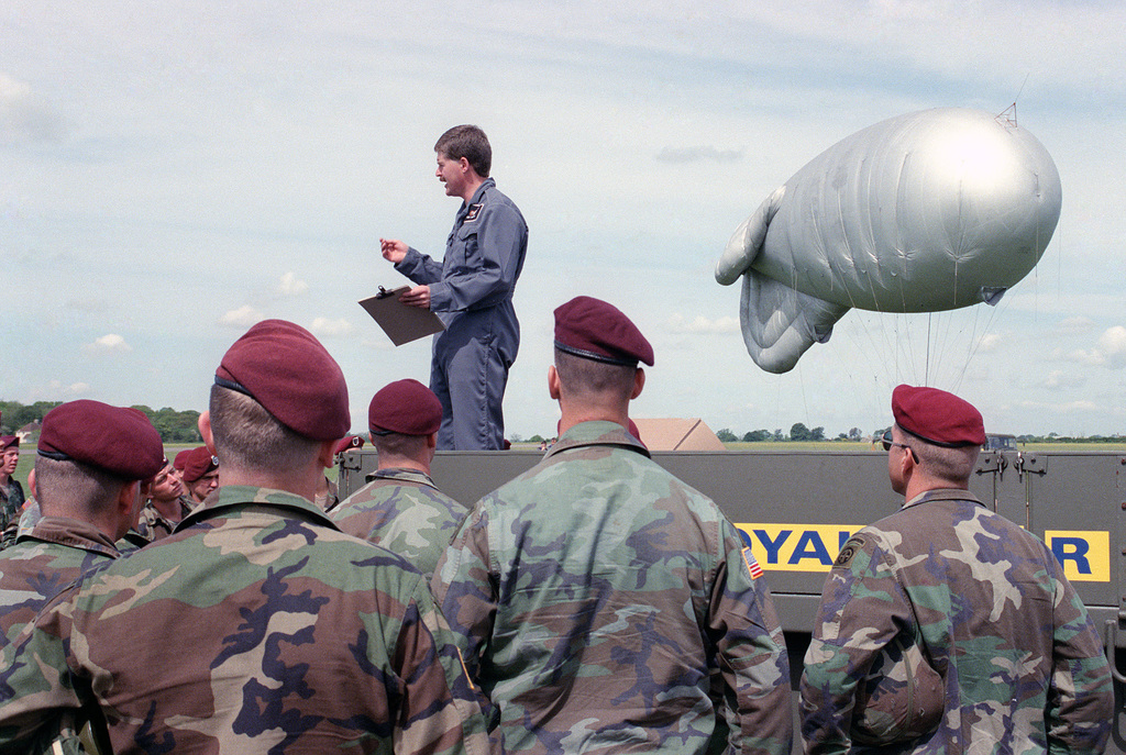 A British paratrooper carries his gear off the landing zone after a  re-enactment of a World War II parachute jump on the 40th anniversary of  D-day, the invasion of Europe - PICRYL 