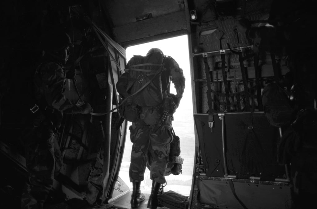 82nd Airborne Division paratroopers jump from an aircraft while ...