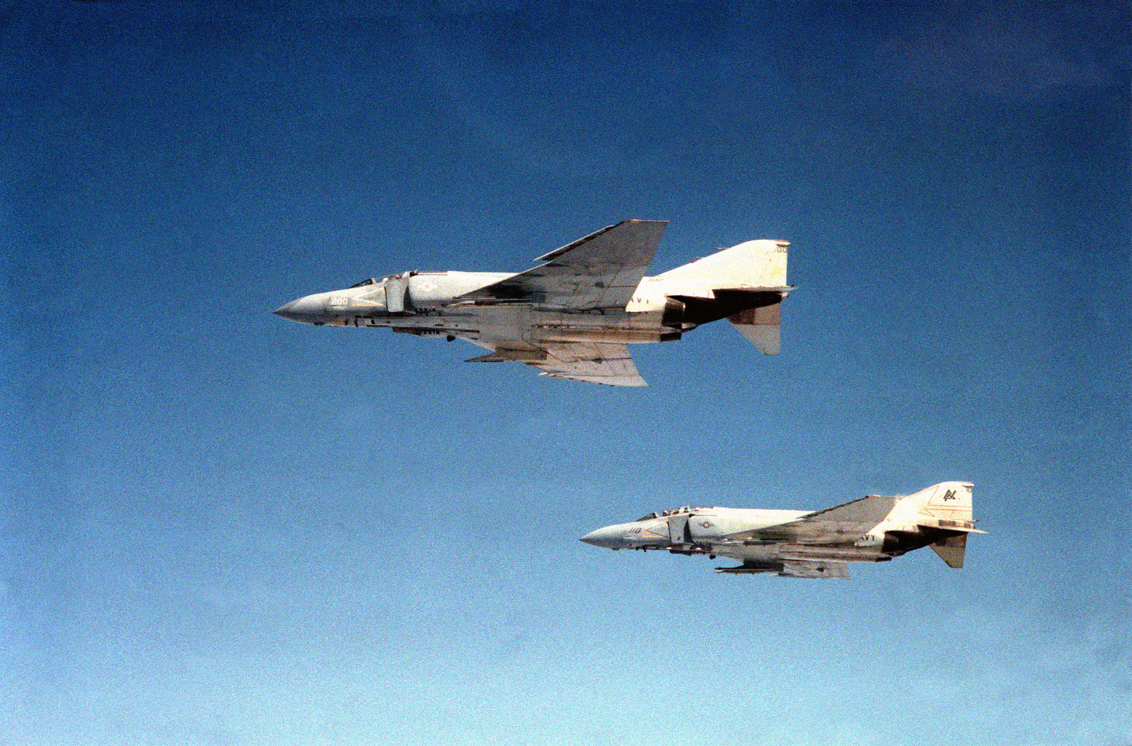 An air-to-air left side view of two F-4S Phantom II aircraft. They are ...