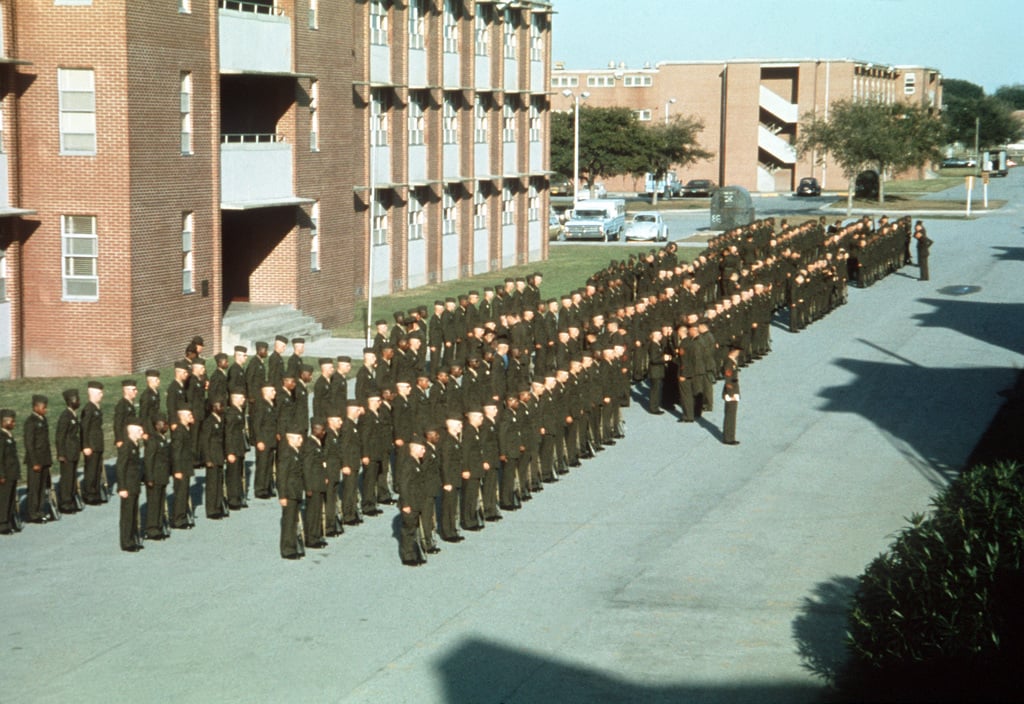 Marine recruits stand in ranks outside their barracks, as a personnel