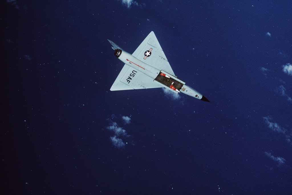 An air-to-air underside view of an F-106 Delta Dart aircraft during the  air-to-air weapons meet WILLIAM TELL '84. Two AIM-4 Super Falcon missiles  are visible in the open internal weapons bay of