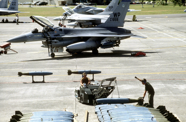 US Air Force (USAF) munitions handler offload BDU-33 practice bombs from a munitions trailers ...