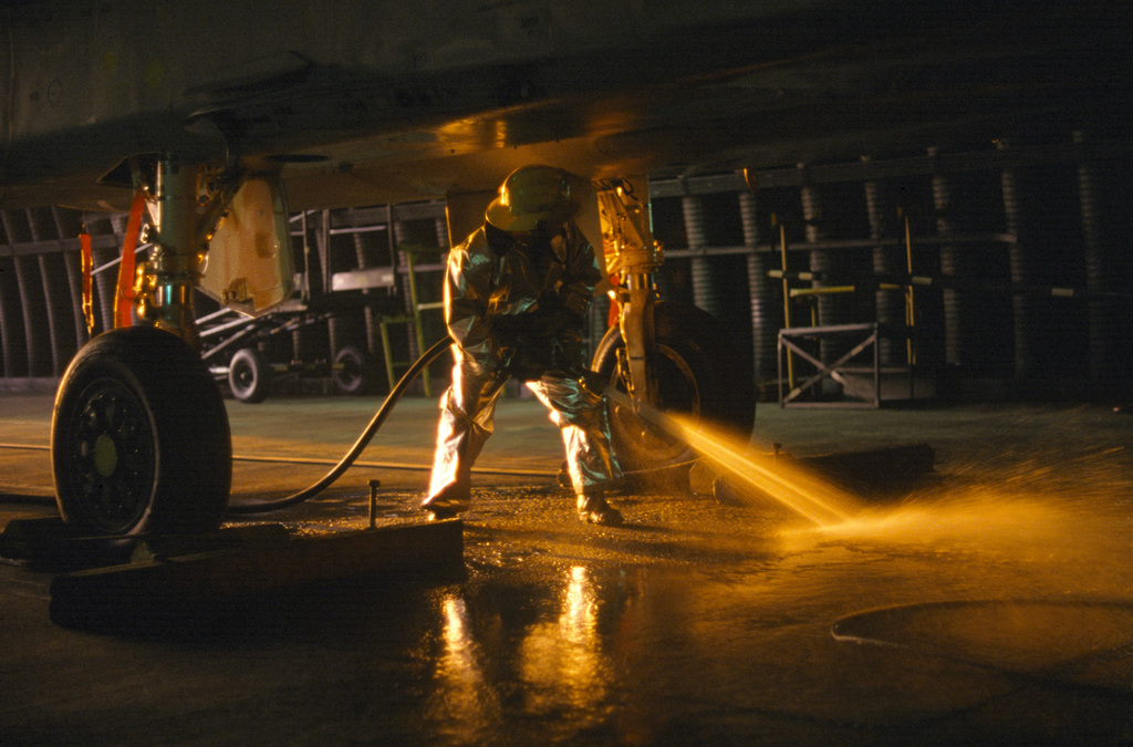 A 36th Civil Engineering Squadron firefighter hoses down a fuel spill ...