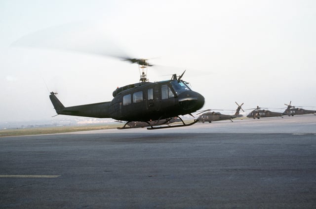 Right side view of a UH-1H Iroquois helicopter hovering over a landing ...