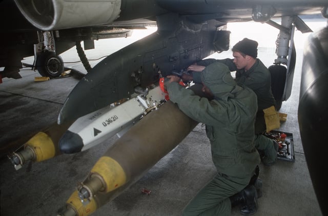 Munitions personnel load bombs onto an F-4E Phantom II aircraft during ...