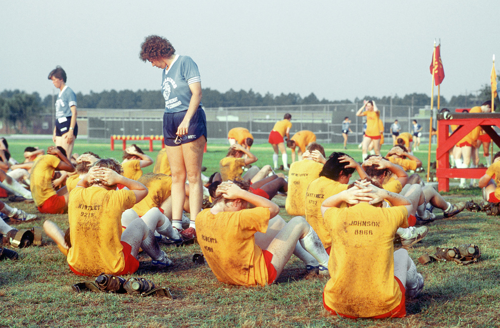 Women Marine recruits perform sit ups during physical training at