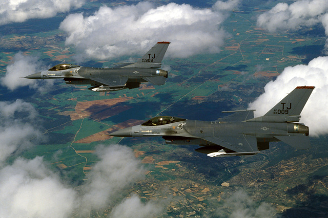 An air-to-air left side view of two F-16A Fighting Falcon aircraft ...