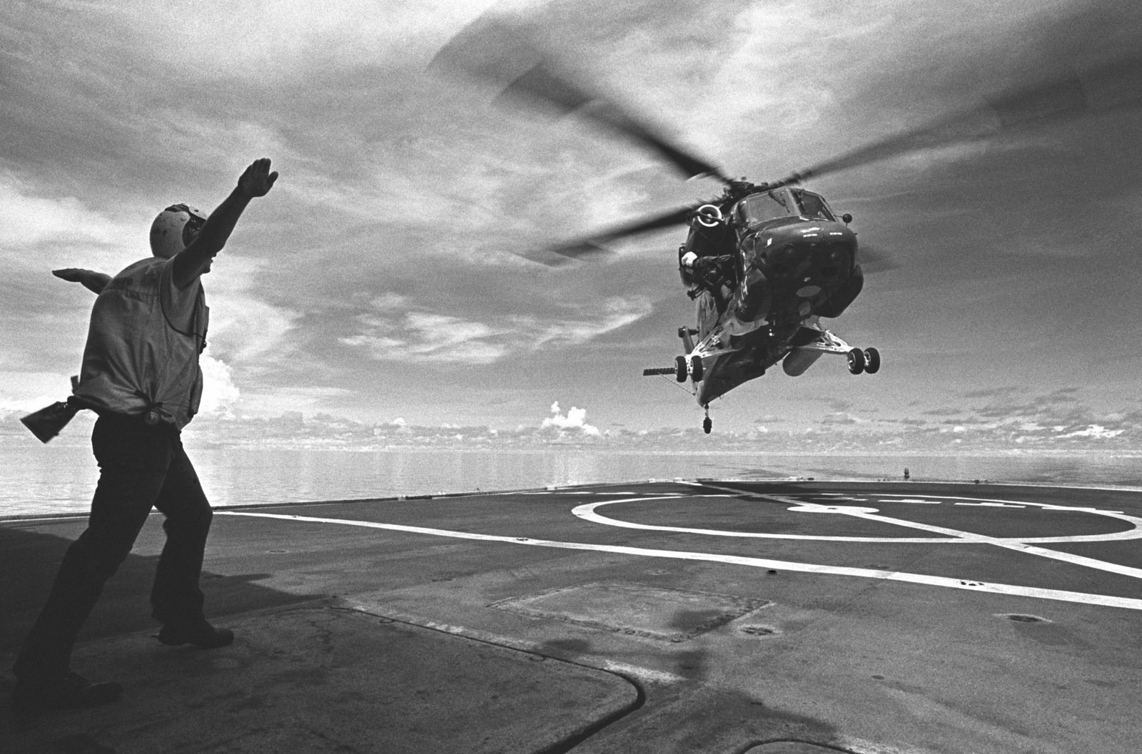 Aviation Machinist's Mate 3rd Class (AD3) Jeffrey C. Bell signals to an ...