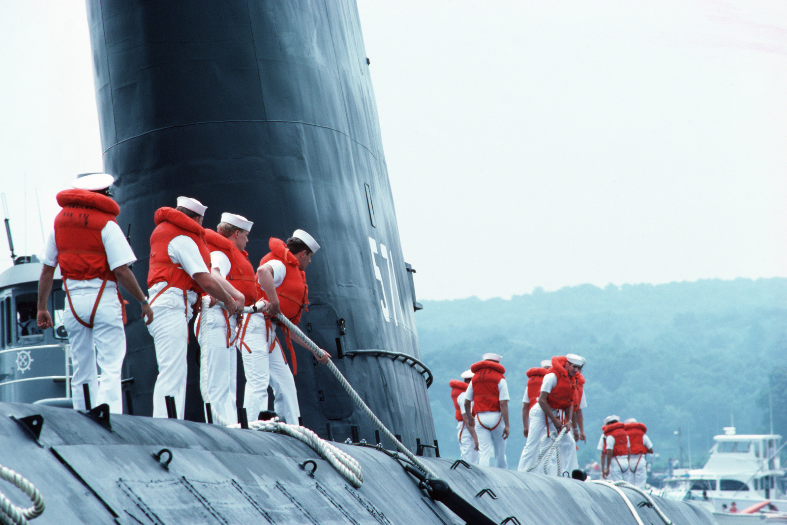 Sailors Handle Mooring Lines As The Decommissioned Nuclear Powered