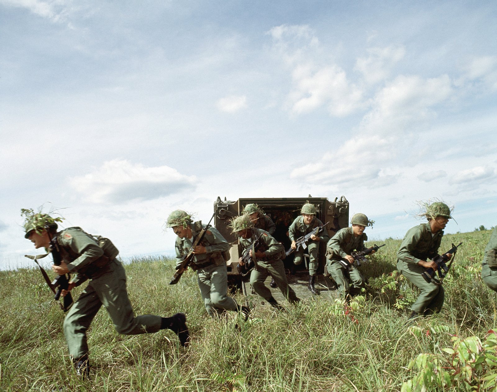 US Army infantrymen armed with M16A1 rifles unload from an M113 armored ...