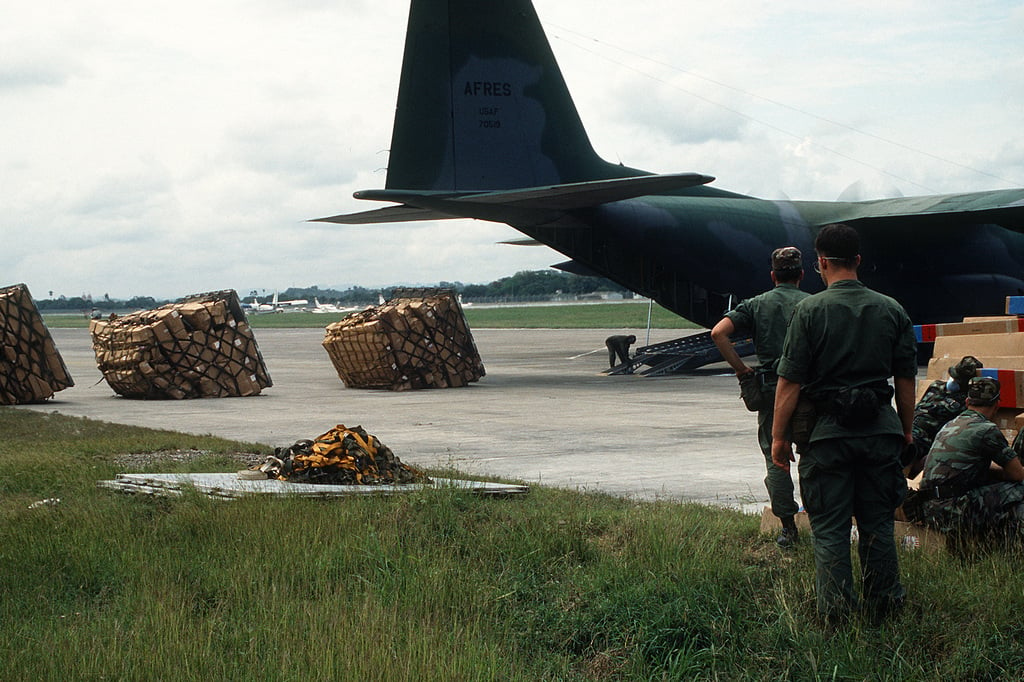 Airmen unload supplies from a C-130 Hercules aircraft for transport to ...