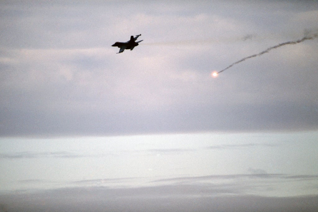 An F-16 Fighting Falcon aircraft releases a decoy flare during Exercise ...