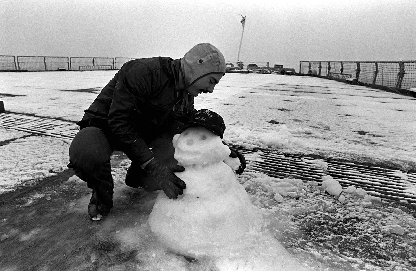 a-crewman-builds-a-snowman-on-the-deck-of-the-battleship-uss-iowa-bb