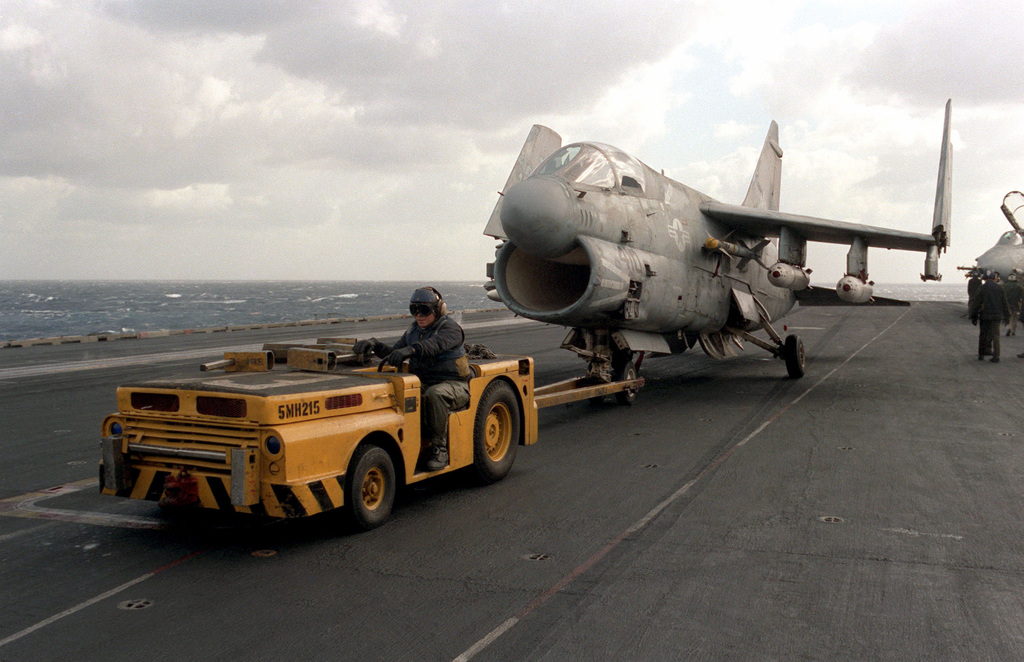 An Md 3a Tow Tractor Pulls An A 7e Corsair Ii Aircraft Along The Flight Deck During Flight 