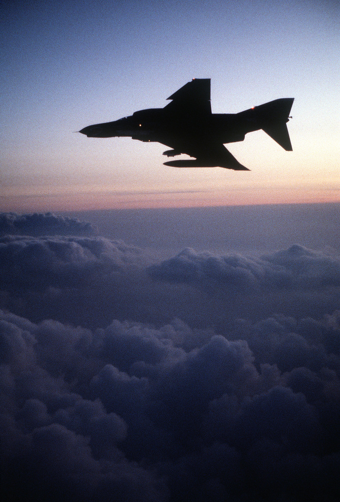 A silhouetted view of a 3rd Tactical Fighter Squadron F-4E Phantom II ...