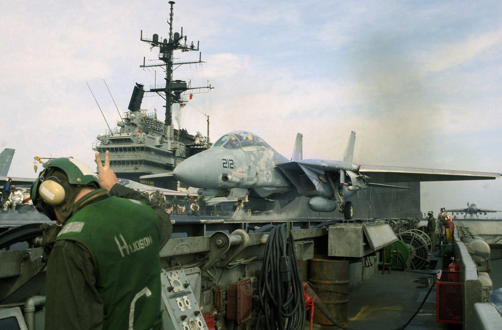 A bow catapult operator prepares to launch an F-14 Tomcat aircraft from ...