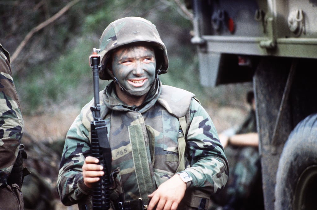 A Marine armed with an M16A2 rifle rests when his squad stops to ...