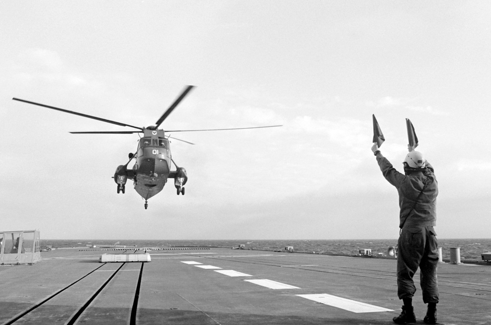 A Flight Deck Crewman Signals Instructions To A Us Navy Sh-3 Sea King 