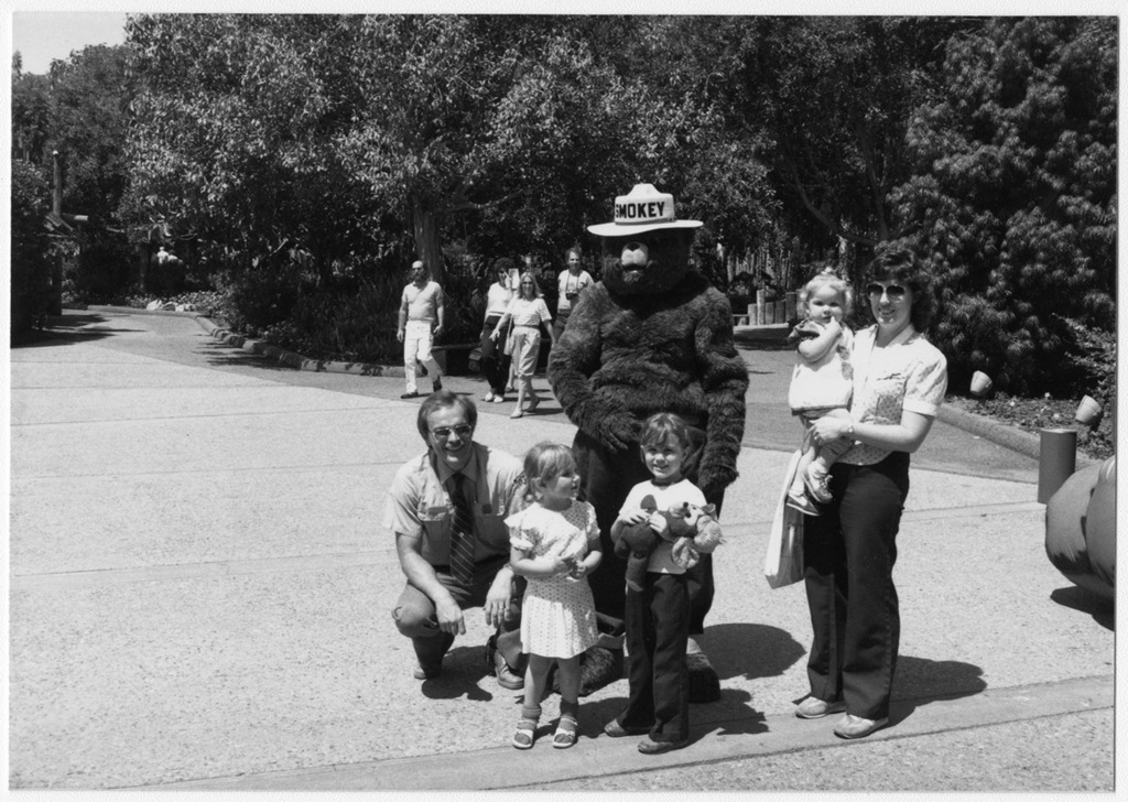smokey bear takes the opportunity to pose for pictures with a family 1e7713 1024