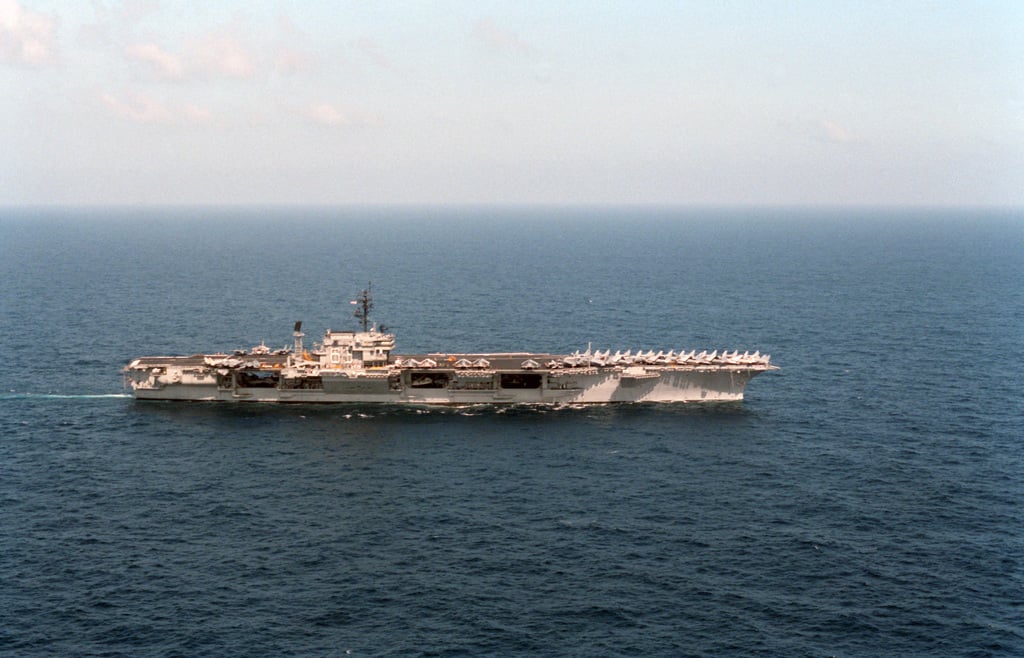 A starboard beam view of the aircraft carrier USS KITTY HAWK (CV 63 ...